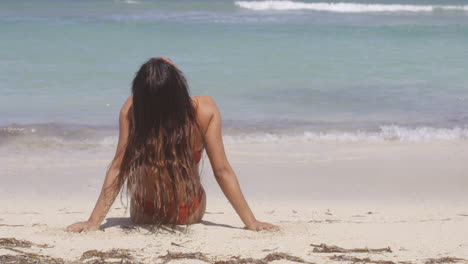 View-Behind-Latino-Girl-Sitting-on-Beach-White-Sands-Enjoying-Tranquillity-of-Ocean-Waves