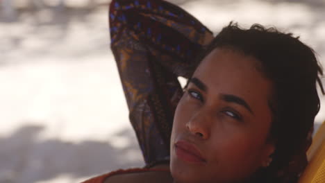 Latin-Brunette-Pretty-Girl-Rests-on-Caribbean-Beach-with-Captivating-Smile,-closeup-tilt