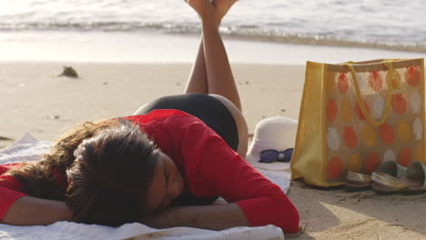 Latino-Girl-Lying-Down-Relaxes-in-Fresh-Summer-Breeze-on-Beach-Sands,-Static-Shot