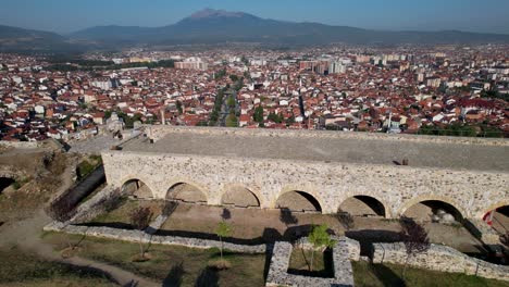 Gewölbte-Steinmauern-Der-Festung-Prizren,-Die-Stadthäuser-Mit-Roten-Dächern-Und-Gassen-Enthüllen