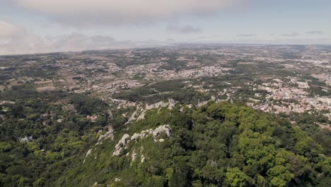 UNESCO-tourist-landmark,-Castle-of-the-Moors-on-hill-in-Sintra-Portugal,-aerial-pan-shot