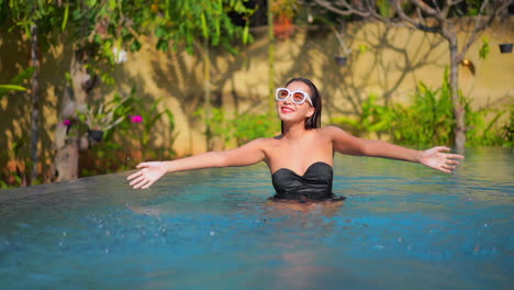 Joyful-Sexy-Exotic-Woman-in-Swimming-Pool-Spraying-Water