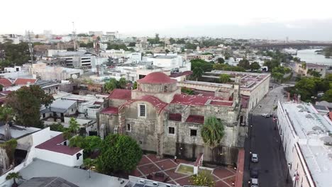 Drone-view-of-flying-over-the-colonial-zone-with-view-of-the-Pantheon-of-the-Homeland,-neoclassical-limestone-mausoleum,-historical-monument-of-Santo-Domingo