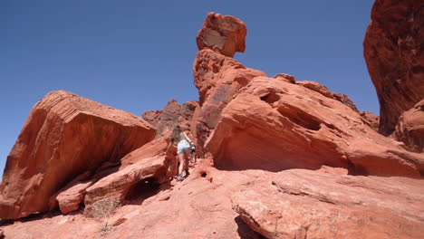 Rückseite-Der-Jungen-Frau-Zu-Fuß-Unter-Roten-Felsformationen,-Valley-Of-Fire-State-Park,-Nevada,-USA