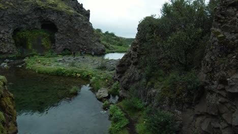 Fliegen-Durch-Die-Höhle-An-Den-Gjain-Wasserfällen,-Malerische-Kaskade-In-Island,-Bewölkter-Tag