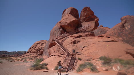 A-Young-Woman-Walking-Toward-Stairs-of-Atlatl-Rock-in-Valley-of-Fire-State-Park