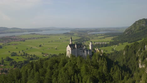 Toma-Aérea-Ascendente-Revela-El-Castillo-De-Neuschwanstein-En-Un-Pintoresco-Día-De-Verano-En-Baviera,-Alemania