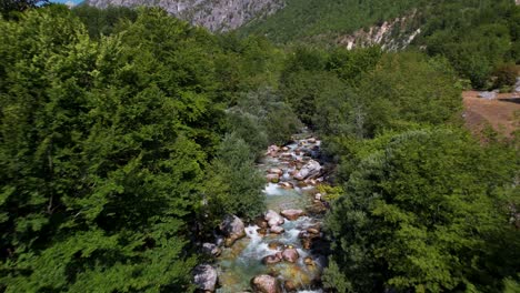 Beautiful-mountain-river-revealing-across-trees-with-clean-water-streaming-on-rocks-in-Northern-Albania