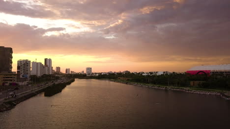 Sonnenuntergang-Luftansicht-Eines-Flusses,-Der-Durch-Ein-Stadtgebiet-Fließt