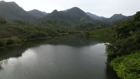 Filmischer-Luftblick-über-Grünen-Walddschungel-Mit-Lagune-Am-Sommertag-In-Honduras,-Mittelamerika