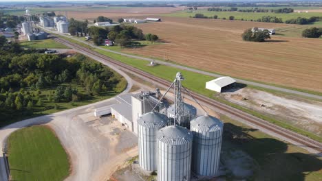 Aerial-orbiting-4K-drone-footage-of-a-farm-with-many-feeding-silos-made-of-steel-near-Trenton,-Kentucky-in-USA