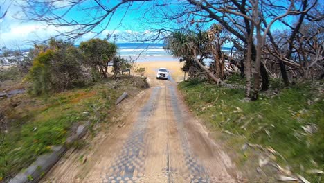 Rear-facing-driving-point-of-view-POV-driving-up-an-inland-track,-from-a-Queensland-beach-under-a-blue-sky-with-other-4x4-trucks---ideal-for-interior-car-scene-green-screen-replacement