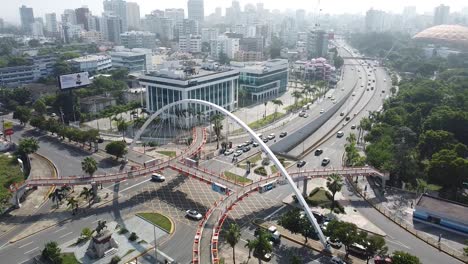 Static-drone-shot-of-the-pedestrian-bridge-with-view-of-buildings-in-the-background,-sunny-weather-in-santo-domingo