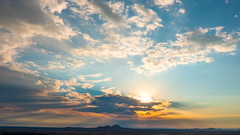 Luftzeitraffer-über-Der-Mojave-Wüste-Mit-Dem-Sonnenschein,-Der-Bei-Sonnenaufgang-Durch-Die-Wolken-Bricht