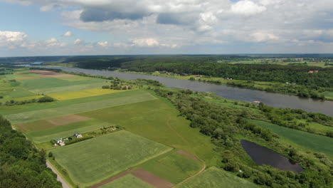 Grüne,-Lebendige-Felder-Und-Wälder-In-Der-Nähe-Des-Flusstals,-Drohnenansicht-Aus-Hohem-Winkel