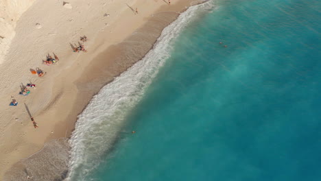 Tourist-Sunbathe-On-Sandy-Shore-Of-Porto-Katsiki-Beach-In-Lefkada-Island,-Greece