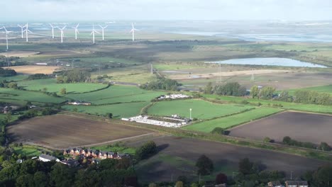 Cheshire-farmland-countryside-wind-farm-turbines-generating-renewable-green-energy-aerial-pan-right-reveal-view
