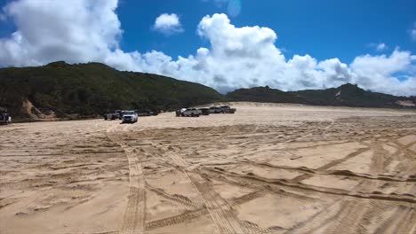 Rear-facing-driving-point-of-view-POV-of-a-busy-Queensland-beach-at-popular-tourist-spot-with-multiple-4x4-trucks-at-Fraser-Island's-Eli-Creek---ideal-for-interior-car-scene-green-screen-replacement