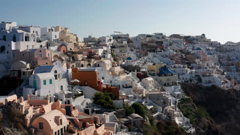 Weiße-Häuser-Und-Gebäude-In-Der-Stadt-Oia-Auf-Der-Insel-Santorini,-Griechenland---Luftrückzug