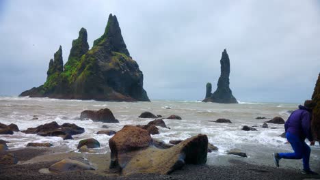 Man-Jumping-From-The-Large-Searock-At-Reynisfjara-Beach-Sightseeing-The-Reynisdrangar-In-Iceland