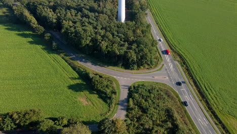 Aerial-View-Of-Vehicles-Driving-On-Rural-Road-Near-Telecommunication-Tower-In-Dotternhausen,-Germany
