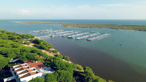Aerial-view-of-El-Rompido-Marina-And-yatchs-moored-at-the-Dock-on-Piedras-river,-Atlantic-ocean-bird's-eyes,-sliding-right