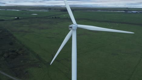 Alternative-green-energy-wind-farm-turbines-spinning-in-Frodsham-Cheshire-fields-aerial-view-high-left-orbit