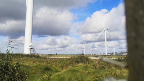 Alternative-green-energy-wind-farm-turbines-spinning-on-breezy-Frodsham-Cheshire-grassland