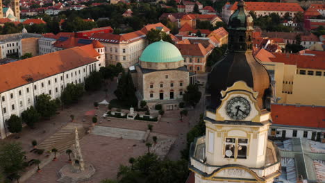 Aerial-View-Of-Mosque-of-Pasha-Qasim-Located-Downtown-On-The-Main-Square-In-Pécs,-Hungary---drone-pullback