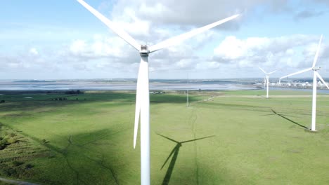Alternative-green-energy-wind-farm-turbines-spinning-in-Frodsham-Cheshire-fields-aerial-view-rising