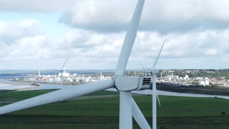 Alternative-green-energy-wind-farm-turbines-spinning-in-Frodsham-Cheshire-fields-aerial-view-rear-closeup