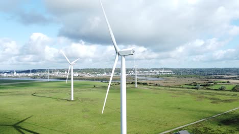 Aerial-view-flying-around-renewable-energy-wind-farm-wind-turbines-spinning-on-British-countryside