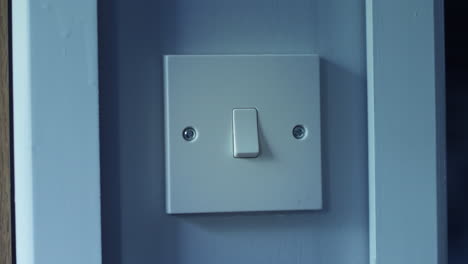 A-light-switch-being-turned-on-at-night-in-a-dark-room