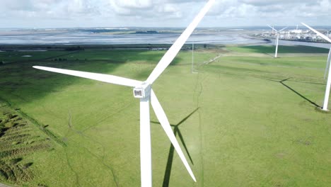Aerial-view-flying-around-renewable-energy-wind-farm-wind-turbines-rotating-on-British-countryside