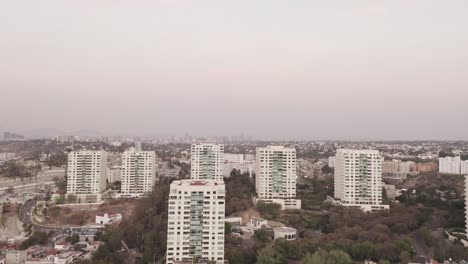 Drone-wide-angle-shot-over-La-Enramada-cityscape-in-Mexico-City-on-overcast-day
