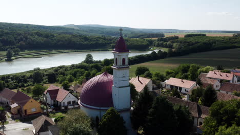 Aerial-View-Of-Ancient-Church-Near-Fishing-Pond-In-The-Village-Of-Palkonya-In-Baranya-County,-Hungary