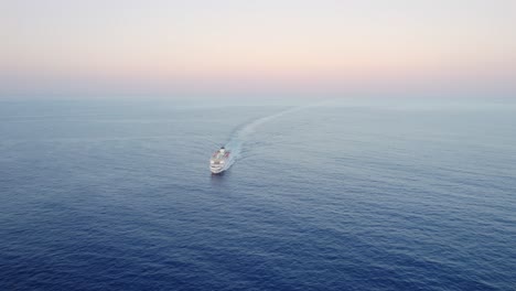 Large-Roro-Ferry-ship-sailing-calm-sea-at-dawn,-high-angle-front-view,-drone-aerial-shot
