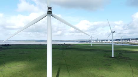 Alternative-Grüne-Energie-Windparkturbinen-Drehen-Sich-In-Frodsham-Cheshire-Fields-Luftaufnahme-Langsame-Rechte-Pfanne