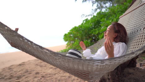 Young-Exotic-Woman-Swinging-in-Hammock,-Sandy-Tropical-Beach-With-Relaxing-View-on-Sea-Horizon,-Full-Frame