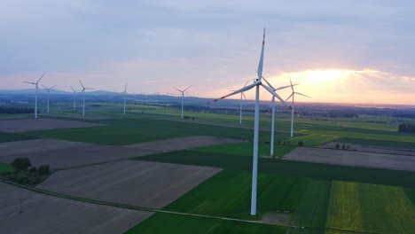 Aerial-forward-flight-towards-a-landscape-of-Wind-Turbines-across-the-Polish-Countryside-during-a-stunning-sunset