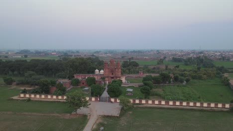 Drone-view-of-Gurdwara-Rori-Sahib-located-in-a-small-village-called-Eminabad-in-Punjab,-Pakistan