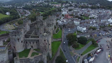 Medieval-Conwy-castle-walled-market-town-aerial-view-pan-right-to-river-harbour-sailboats