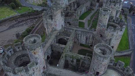 Medieval-Conwy-castle-walled-market-town-aerial-view-rising-to-birdseye