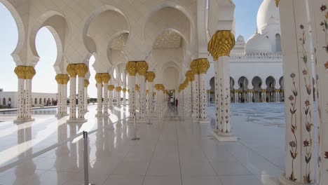 Zeitlupengang-Durch-Den-Weiß-goldenen-Flur-Der-Großen-Moschee-In-Abu-Dhabi