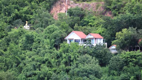 Kaeng-Krachan-with-a-small-house-and-temple-on-the-hillside-with-a-slow-zoom-in-Thailand