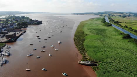 Szenische-Luftaufnahme-Von-Segelbooten,-Die-Im-Fluss-Exe-Neben-Grünen-Feldern-Und-Dem-Exeter-Kanal-Verankert-Sind