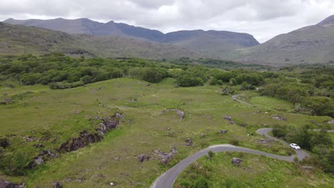 Curvy-road-winding-through-rugged-rural-Irish-landscape,-an-aerial-view