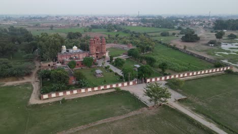 Drone-view-of-Gurdwara-Rori-Sahib-located-in-a-small-village-called-Eminabad-in-Punjab,-Pakistan