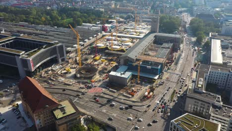 Aerial-of-huge-railroads,-intersection-and-construction-site-of-main-train-station-Stuttgart-S21-with-cranes-and-construction-worker-in-Stuttgart,-Germany