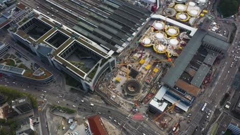Aerial-of-huge-railroads-and-construction-site-of-main-train-station-Stuttgart-S21-with-cranes-and-construction-workers-in-Stuttgart,-Germany